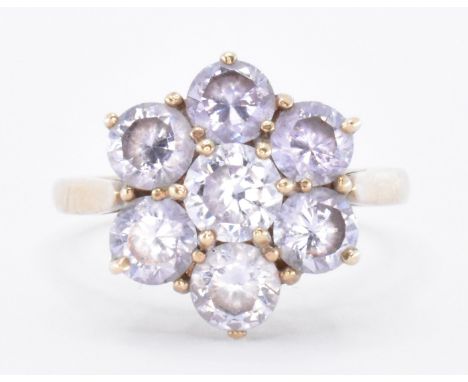 A hallmarked 9ct gold and amethyst flower head cluster ring. The ring being set with seven round cut amethysts. Hallmarked Lo