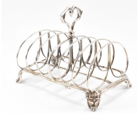 A 19th Century Victorian silver hallmarked toast rack having six sections with scrolled sections raised on scrolled feet with