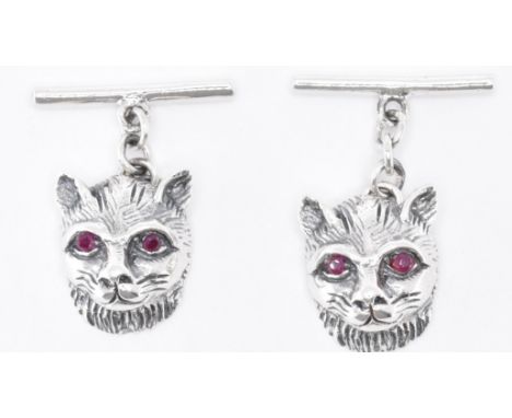 A pair of sterling silver cufflinks in the form of cats being set with round cut ruby eyes. Marked Sterling. Weight 5.1g. Hea