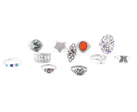 A collection of eleven 925 silver rings. The rings including a star signet ring, carnelian, moss agate, turquoise, lapis lazu