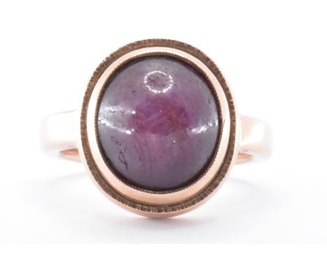 A hallmarked 9ct gold and star ruby ring. The ring having a bezel set oval star ruby cabochon to plain band. Hallmarked Birmi
