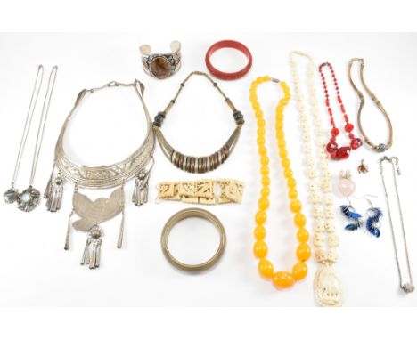 A collection of vintage jewellery to include a simulated amber necklace, a tribal silver white metal collar necklace, a cinna