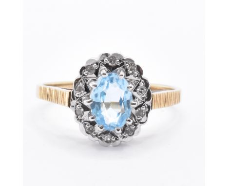 A hallmarked 9ct gold diamond and topaz ring. The ring being set with a central oval cut blue topaz with a halo of diamonds. 