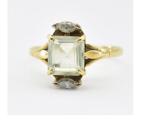 A hallmarked 18ct gold beryl and diamond cocktail ring. The ring set with an emerald cut yellow beryl flanked by to marquise 