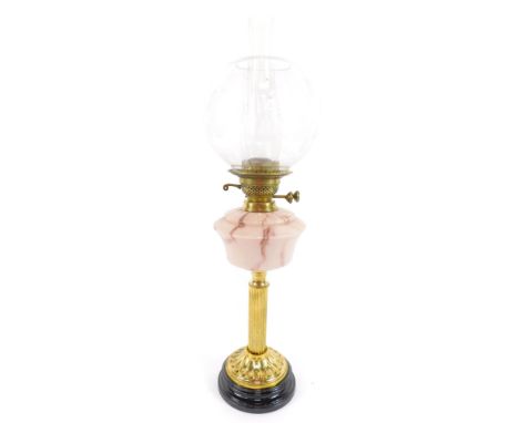 A duplex brass fluted oil lamp, with a marbled pink glass reservoir, raised on a circular fluted base and black glass socle, 