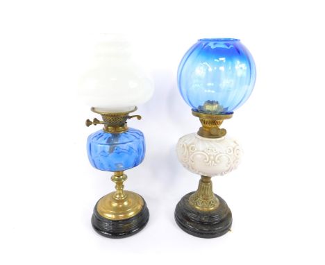 A Victorian brass oil lamp, with a white opaline glass reservoir, with moulded C scrolls, raised on a black circular socle ba