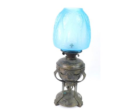 A Jugendstil brass oil lamp, of urn form, raised on a circular base, with a turquoise etched and frosted blue glass shade, 51