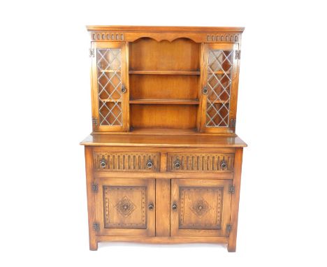 An Old Charm style oak dresser, the three shelf Delft rack flanked by two led panelled doors enclosing two shelves over two l