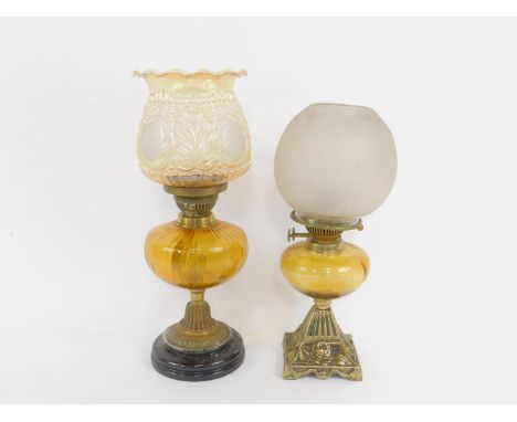 A brass oil lamp, embossed with roses, with yellow glass reservoir, and globular frosted glass shade, 44cm high, together wit