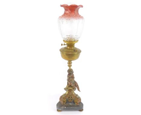 A cast metal and brass oil lamp, cast as a seated girl on a triform scrolling leaf base, on a black marble base, with chimney