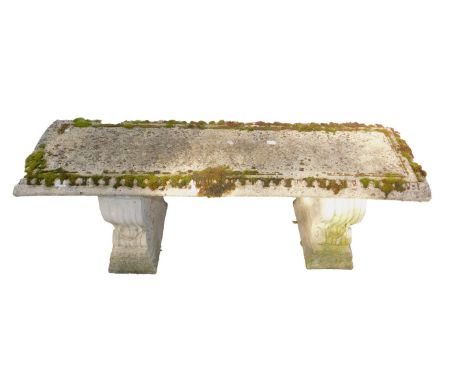 A concrete garden bench, the rectangular top raised on two scroll supports, 44cm H, 127cm L, 38cm D.