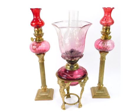 A pair of brass Corinthian column and cranberry glass oil lamps, by Gaudard, France, with ruby glass shades, 44cm high, toget