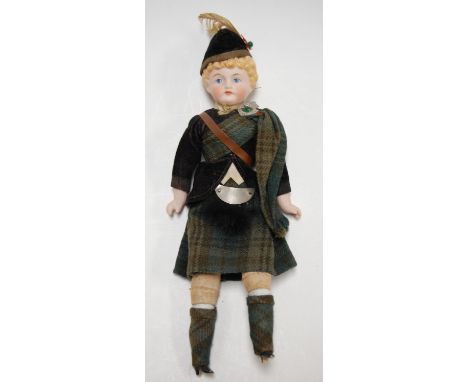 A bisque head doll, having moulded light brown hair with painted blue eyes and features, having stuffed body with bisque limb