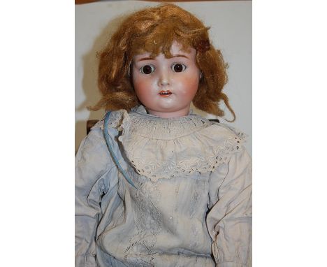 A German bisque head doll, possibly Handwerck, having rolling brown eyes and open mouth with four top teeth showing, with joi