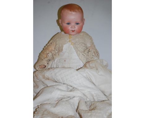 An Armand Marseille bisque head doll, having rolling blue eyes and open mouth with two bottom teeth showing, having bent limb