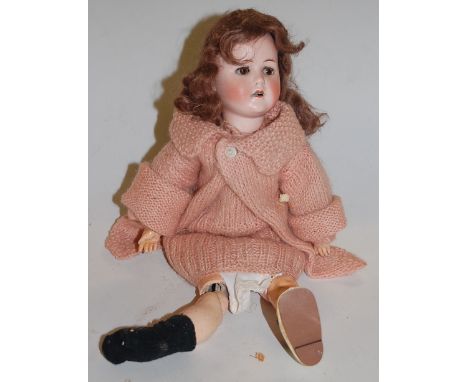 A Max Handwerck Bébé Elite bisque head doll, having rolling brown eyes and open mouth with four top teeth showing, with joint