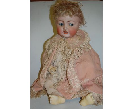 A Kammer &amp; Reinhardt for Simon &amp; Halbig bisque head doll, having rolling blue eyes and open mouth with teeth showing 