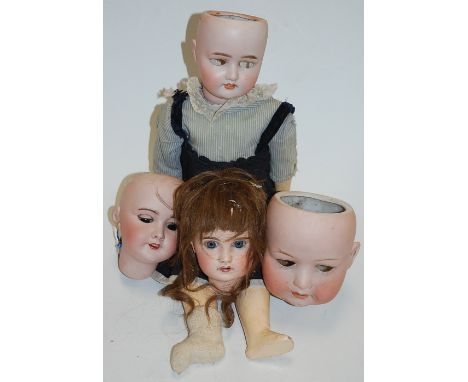 A Schoenau &amp; Hoffmeister bisque head doll, lacking eyes, having open mouth with four top teeth showing, with jointed comp