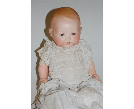 An Armand Marseille bisque head doll, having rolling brown eyes and open mouth with two bottom teeth showing, having bent lim