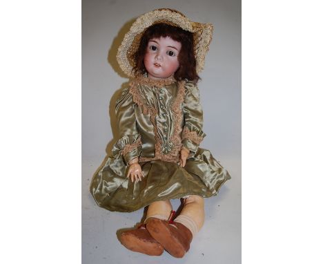 A Max Handwerck bisque head doll, having rolling brown eyes and open mouth with five top teeth showing, with jointed composit