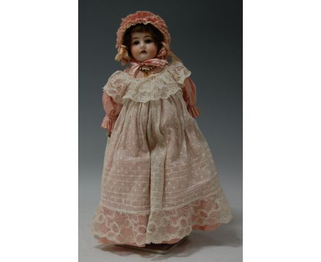 A Heinrich Handwerck bisque head doll, having rolling brown eyes, open mouth with four teeth showing, having kid leather body