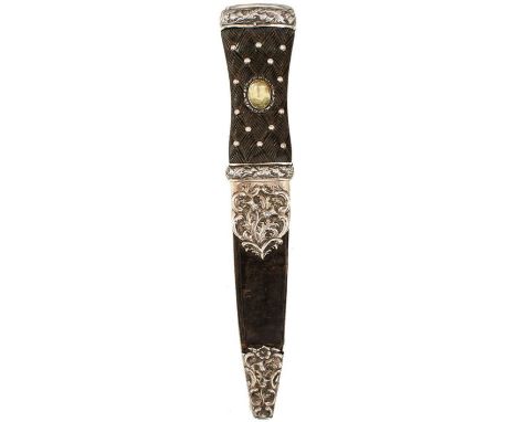 AN ORNATE VICTORIAN SILVER MOUNTED SCOTTISH SGIAN DUBH, 11cm blade with faceted back edge, characteristic hilt with chased si