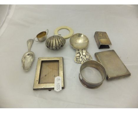 A collection of silver wares to include a Victorian teether with scallop shell rattle, an Arts and Crafts style caddy spoon w