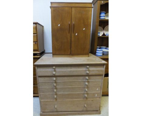 A limed oak art chest, the plain top above a pair of small drawers, above six further long drawers, raised on a plinth base, 