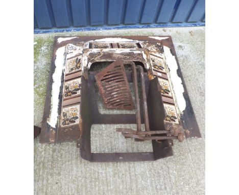 A Victorian cast iron fire surround with ceramic tile inserts depicting primulas togeather with fire basket and pair of dogs