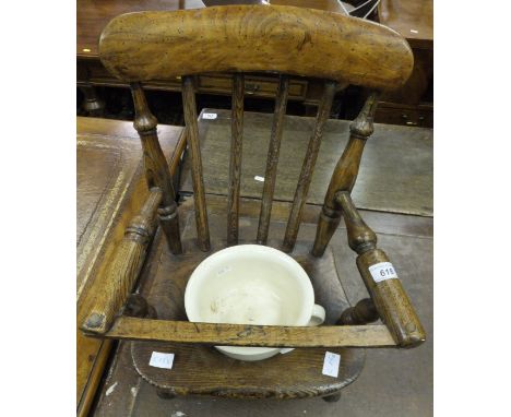 A 19th Century child's elm stick back commode chair with china chamber pot