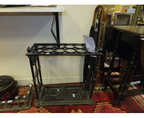 A Victorian painted cast iron twelve section stick stand, together with two umbrellas and a machine made terracotta rug CONDI