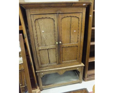 An oak two door cupboard on a table stand