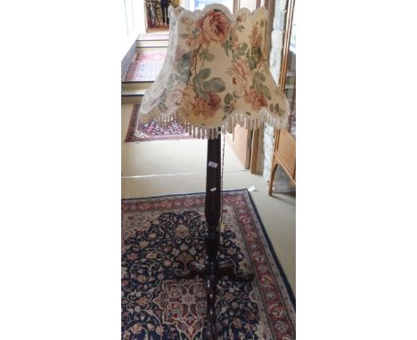 A mahogany standard lamp, the three legs terminating in claw and ball feet