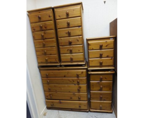 A pair of modern pine chests of drawers, the plain tops above six drawers, raised on bun feet, together with a similar four d