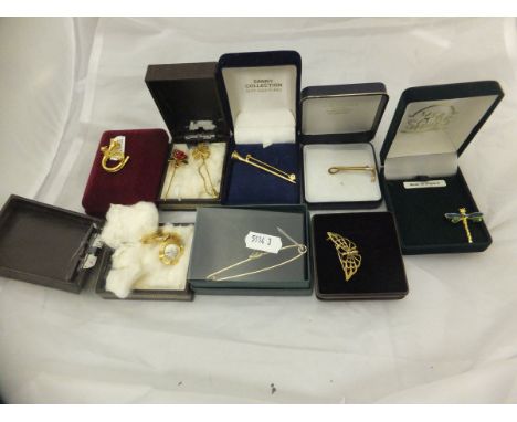 A collection of 9 carat gold and other brooches, tie pins, etc