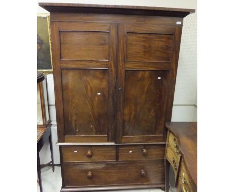 A Victorian mahogany linen press with two cupboard doors over two dummy drawers and a single long drawer (linen press convers