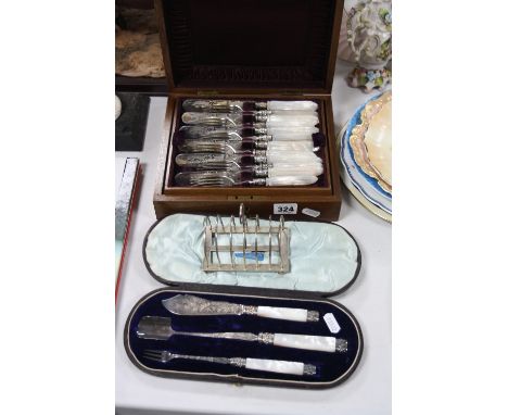 A LATE VICTORIAN WALNUT CASED SET OF TWELVE MOTHER OF PEARL HANDLED DESSERT KNIVES AND FORKS, together with a plated toast ra