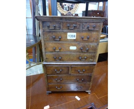 A 20TH CENTURY MINIATURE CHEST, on chest with ten various drawers on bracket feet supports