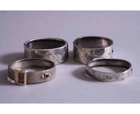 A LATE VICTORIAN HINGED SILVER BANGLE, engraved ivy leaf design, Birmingham 1882, together with another Birmingham 1885, a wh
