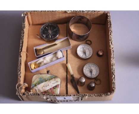 A BOX OF MISCELLANEOUS, to include three compasses, two thimbles, novelty silver bookmark moulded as a trowel, napkin ring, e