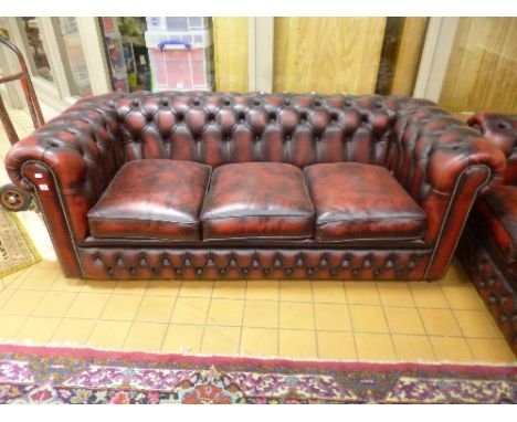 A RED LEATHER CHESTERFIELD, three seater sofa bed