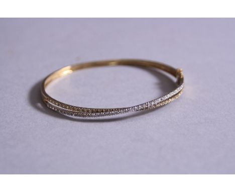 A 9CT DIAMOND SET BANGLE