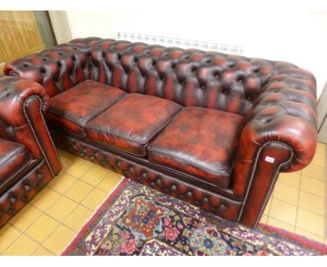 A RED LEATHER CHESTERFIELD, three seater sofa bed