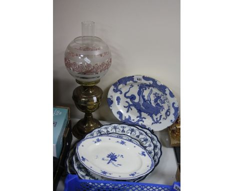 A BRASS BASED OIL LAMP, with spherical glass shade and five blue and white oval meat plates (6)