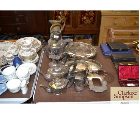 A quantity of platedware to include a teaset, salvers, a copper ships lamp, and a brass jug