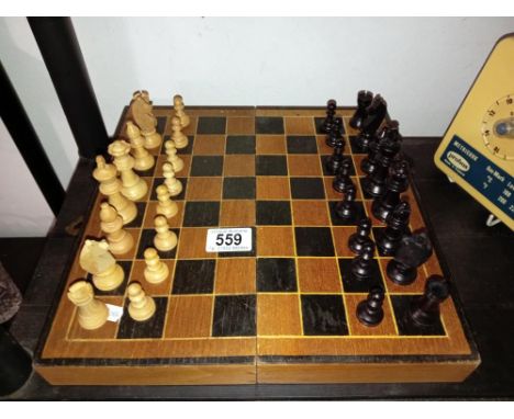 A vintage wooden chess set with folding board box