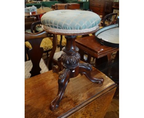 A Victorian mahogany upholstered piano stool, having carved decoration on tripod supports (31cm diameter). Condition Report: 