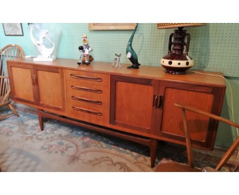 A 1970's G-Plan sideboard, having four central drawers flanked by two-door cupboards on typical support (213cm), together wit