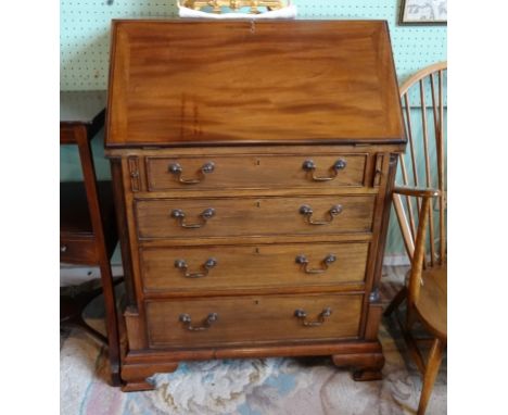 A reproduction mahogany bureau, the interior having inlaid central cupboard drawer, flanked by shelves and drawers over four 
