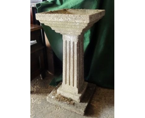 A reconstituted stone planter, the square top over fluted column on a square base (88cm tall).